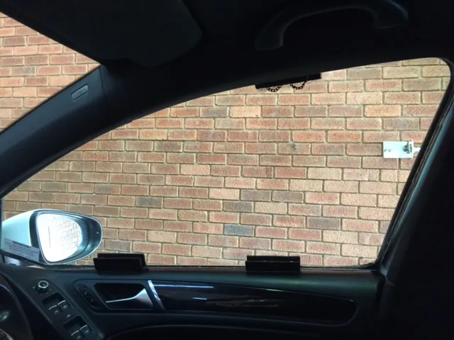 View from the driver’s seat through a side window fitted with Mod Clip panels, held by two clips on the door sill